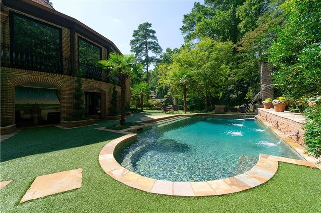 view of pool featuring a yard, pool water feature, and a patio area