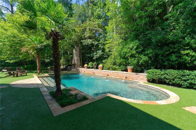 view of swimming pool featuring a yard, pool water feature, and a patio area