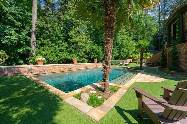 view of swimming pool featuring a lawn, pool water feature, and a patio area