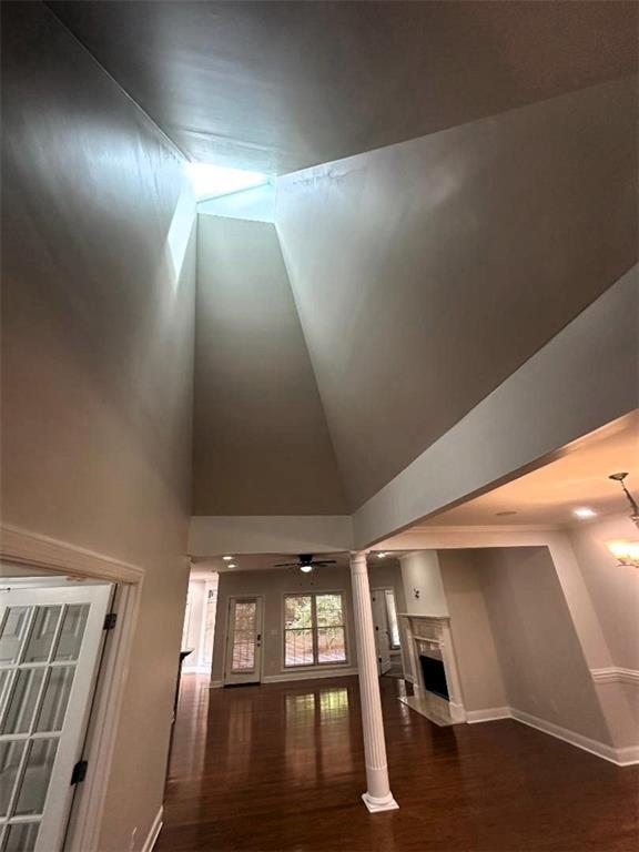 114 Vinings Way SE, Calhoun, GA 30701 - unfurnished living room featuring wood finished floors, baseboards, a ceiling fan, decorative columns, and high vaulted ceiling