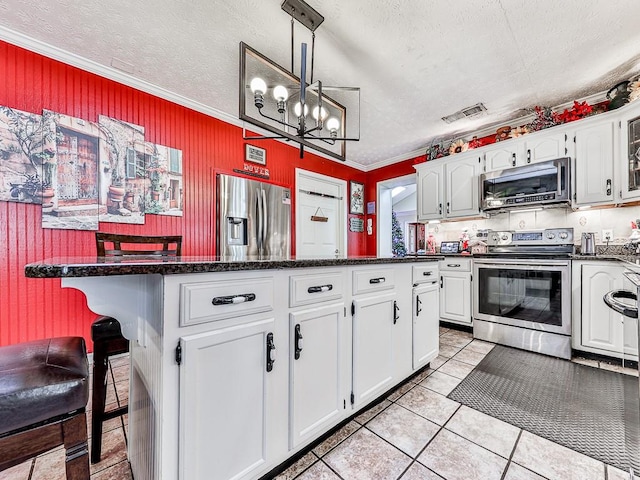 kitchen with white cabinets, a textured ceiling, crown molding, pendant lighting, and appliances with stainless steel finishes