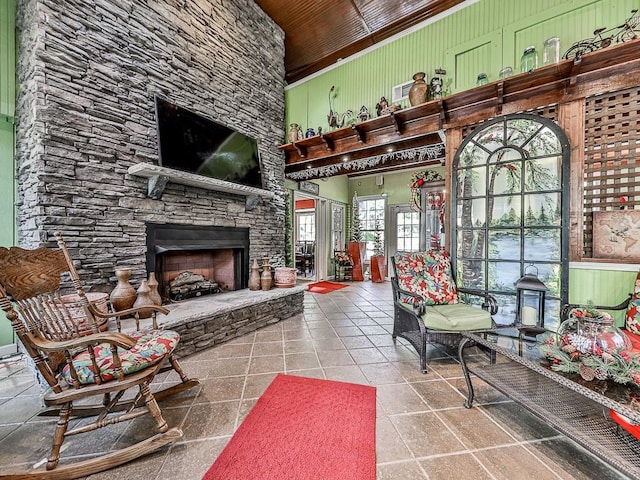 living room featuring a fireplace, a wealth of natural light, a high ceiling, and wooden ceiling