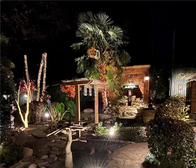 yard at night featuring a patio area