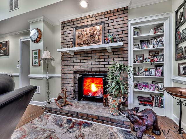 living room featuring a fireplace, hardwood / wood-style flooring, and crown molding