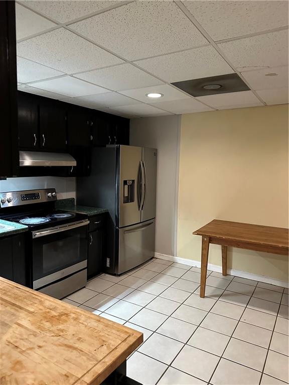 kitchen featuring a drop ceiling, appliances with stainless steel finishes, and light tile patterned floors