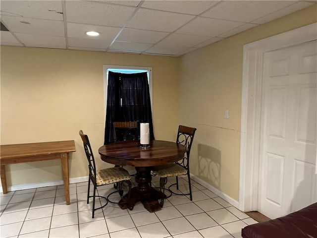 tiled dining room with a drop ceiling