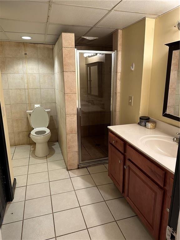 bathroom featuring tile patterned flooring, vanity, toilet, and a shower with shower door