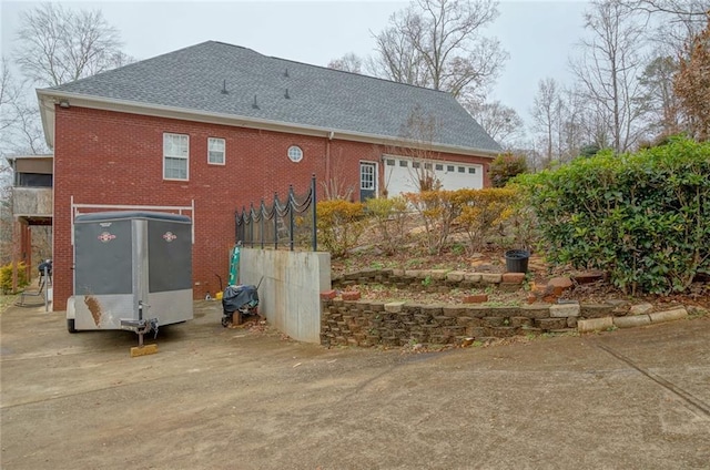 rear view of property with brick siding and roof with shingles