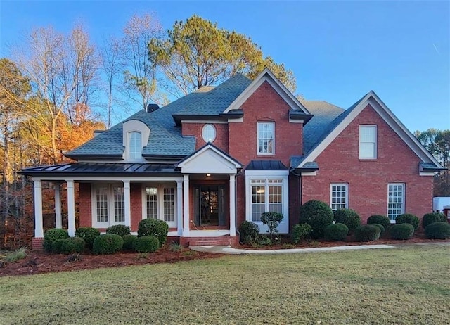 view of front of house with a front yard and covered porch