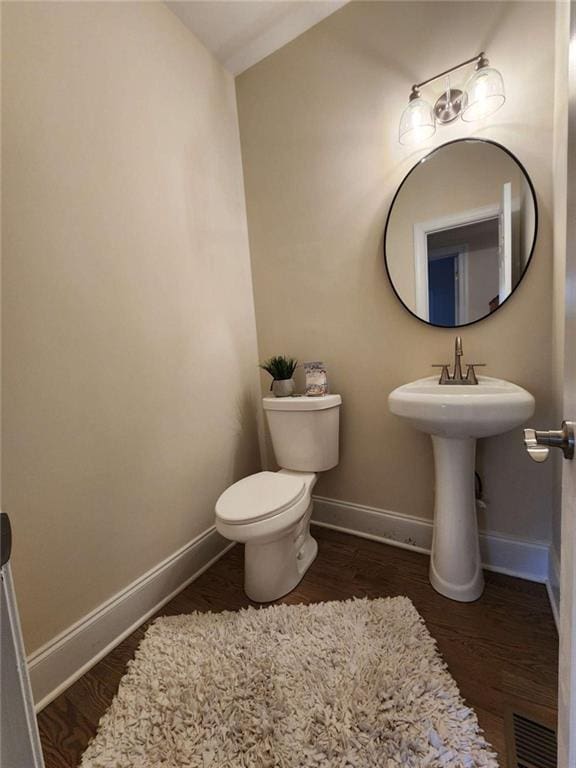 bathroom with wood-type flooring, lofted ceiling, and toilet