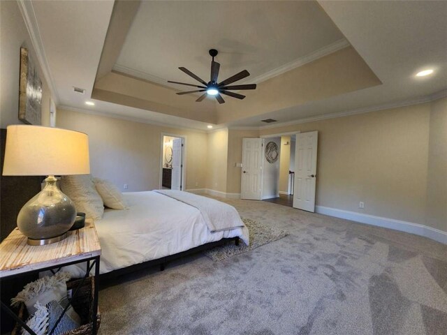 carpeted bedroom featuring crown molding and a raised ceiling