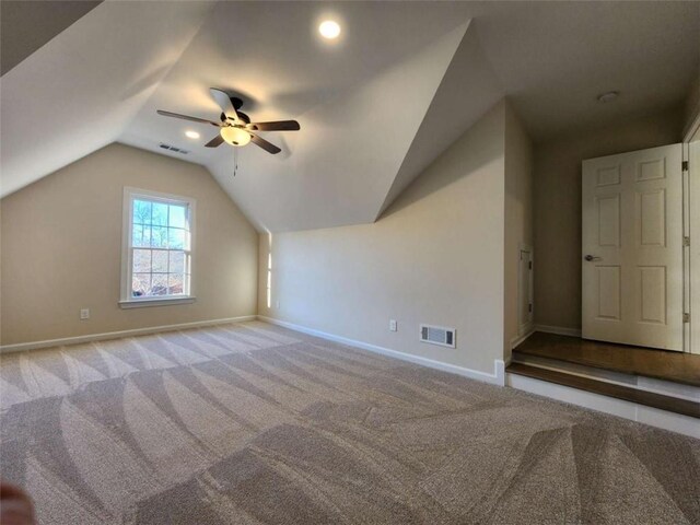 additional living space featuring vaulted ceiling, light colored carpet, and ceiling fan