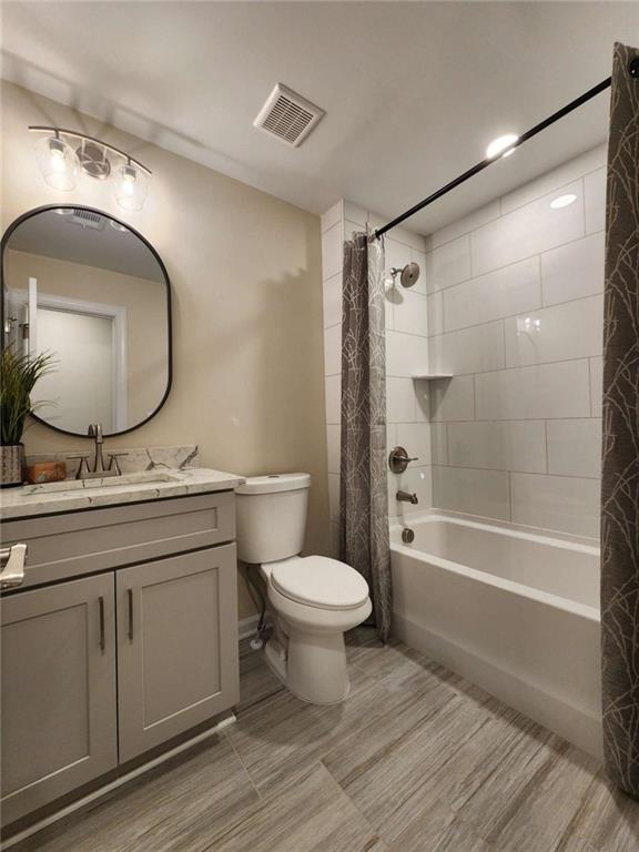 full bathroom with shower / tub combo, vanity, and toilet