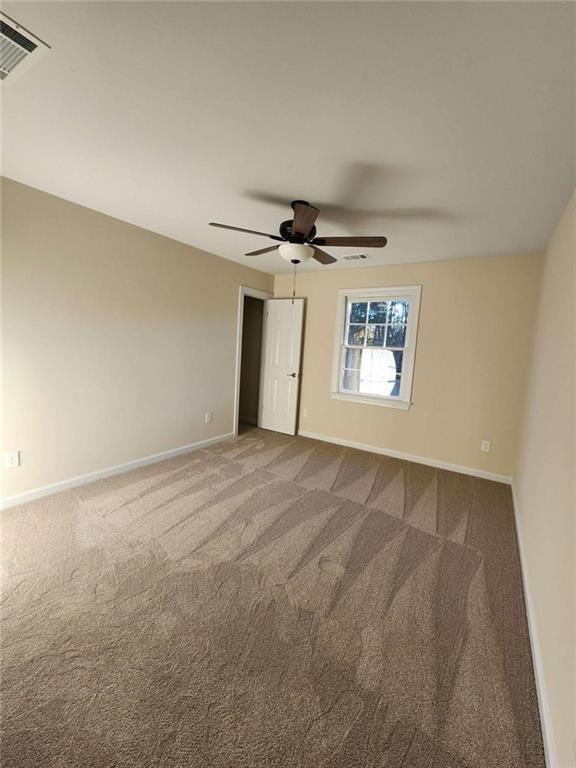 carpeted empty room featuring ceiling fan