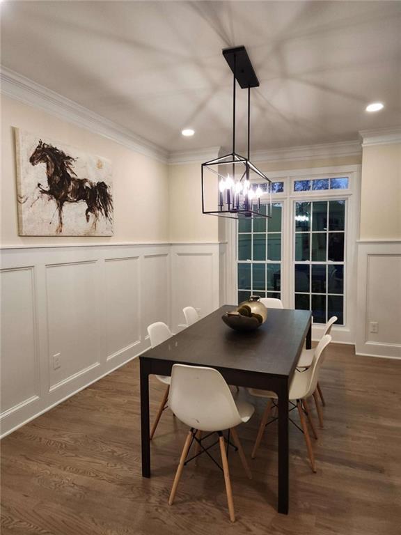 dining room with dark wood-type flooring and crown molding