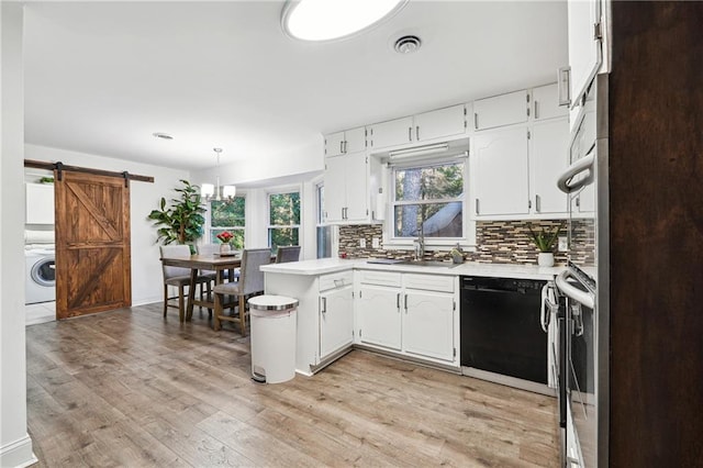 kitchen featuring a barn door, light hardwood / wood-style flooring, white cabinets, black dishwasher, and washer / clothes dryer