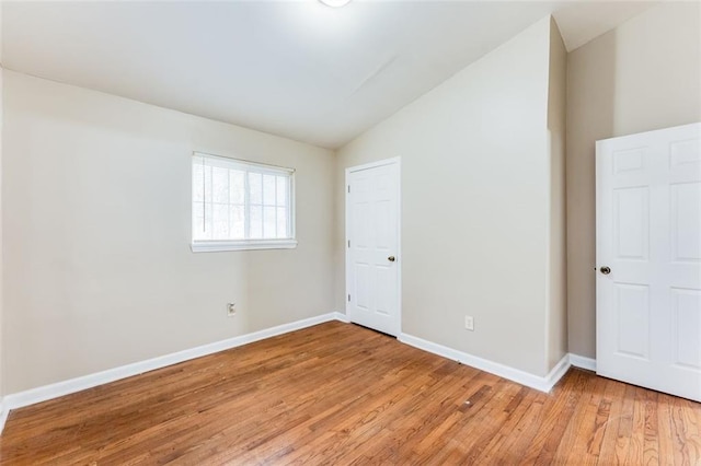 unfurnished bedroom featuring vaulted ceiling and light hardwood / wood-style flooring