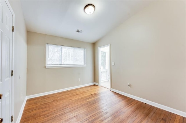 unfurnished bedroom with lofted ceiling and light hardwood / wood-style floors