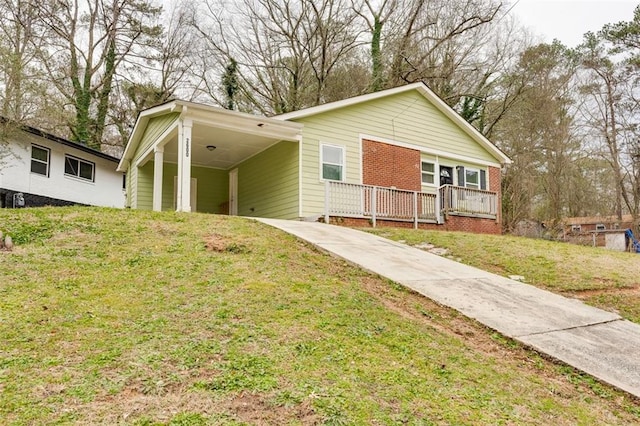 view of front of home featuring a carport, covered porch, and a front yard