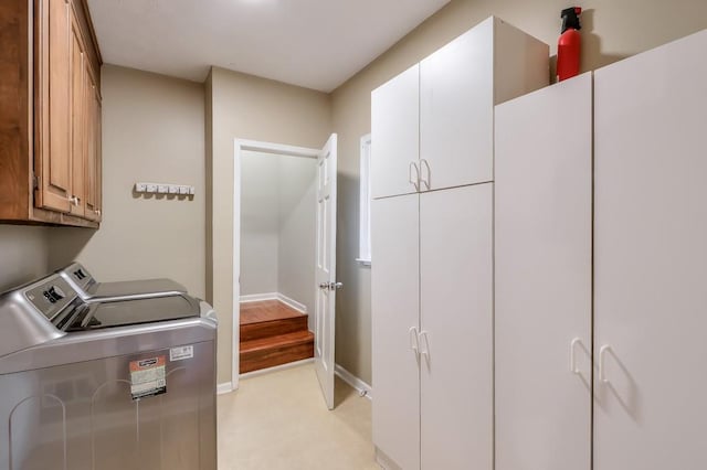 laundry area featuring washer and clothes dryer and cabinets