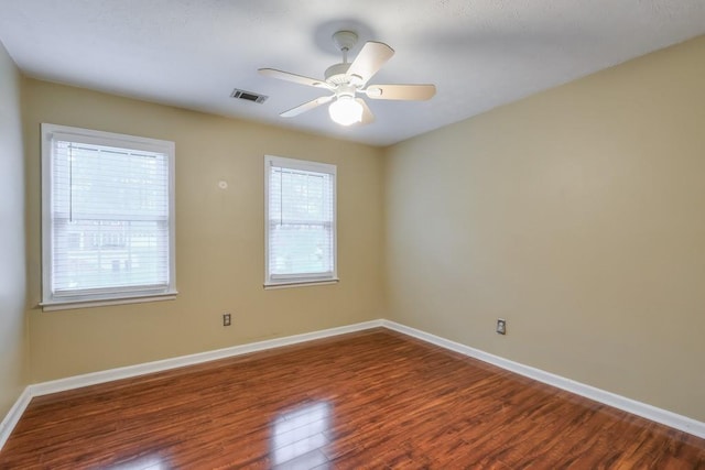 empty room featuring dark wood-type flooring and ceiling fan