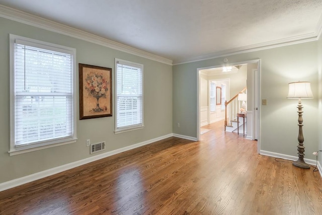 spare room featuring hardwood / wood-style flooring and ornamental molding