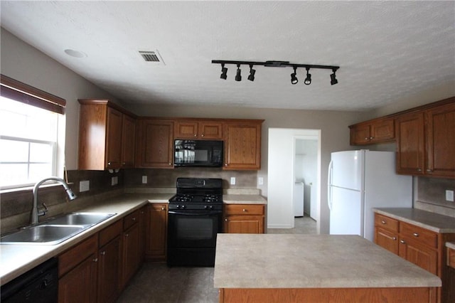 kitchen with a center island, visible vents, decorative backsplash, a sink, and black appliances