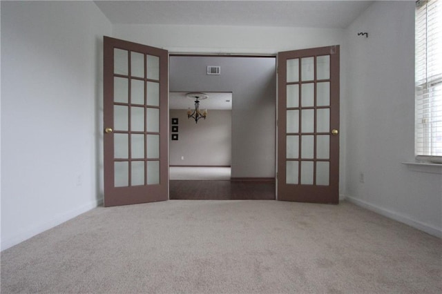 spare room with carpet, french doors, and visible vents