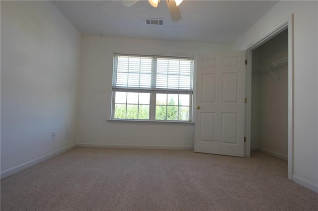 unfurnished bedroom featuring a ceiling fan, light colored carpet, visible vents, and baseboards