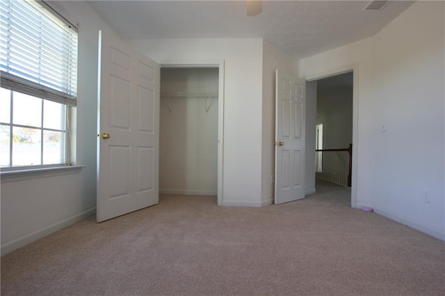 unfurnished bedroom with baseboards, carpet, visible vents, and a closet