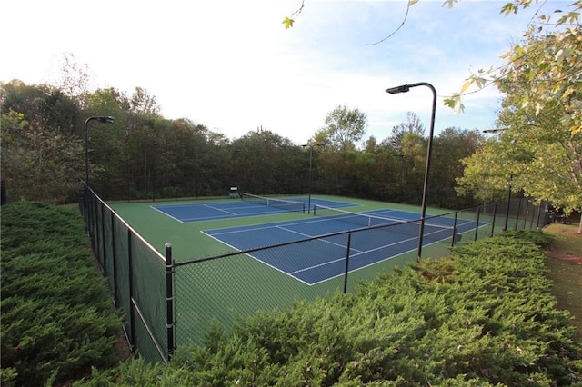 view of tennis court featuring fence