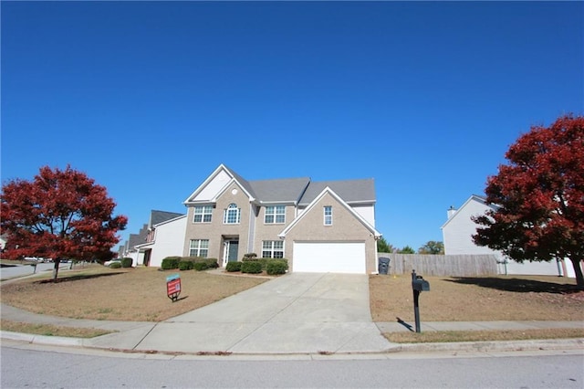 view of front of house featuring a garage, driveway, a front lawn, and fence