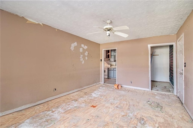 unfurnished bedroom featuring a textured ceiling, baseboards, and a ceiling fan