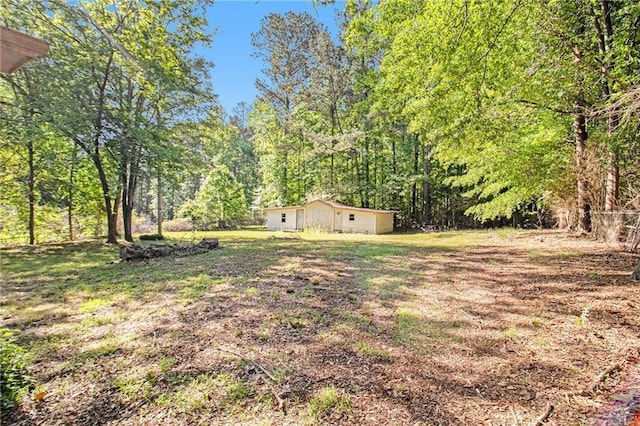 view of yard featuring an outbuilding and a forest view