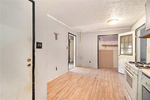 kitchen with white gas range, light wood-style floors, and a textured ceiling