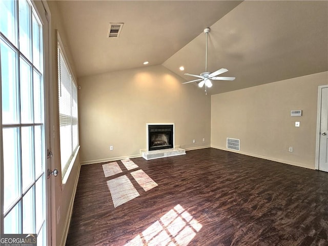 unfurnished living room featuring lofted ceiling, dark wood finished floors, visible vents, and a fireplace with raised hearth