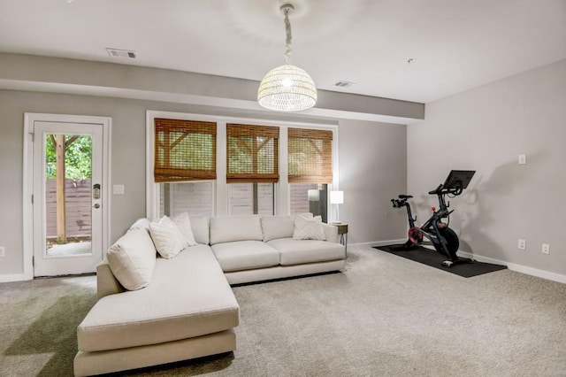 living room featuring carpet and an inviting chandelier