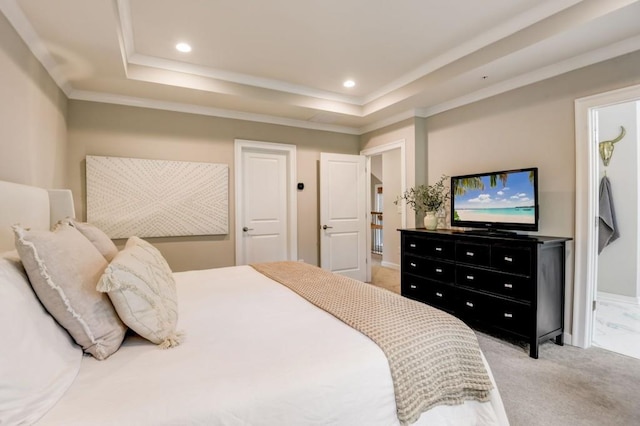 bedroom with light colored carpet and a tray ceiling