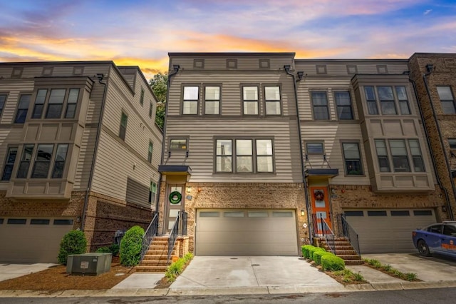 townhome / multi-family property featuring central AC and a garage