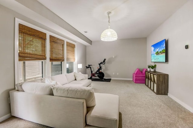 carpeted living room featuring a notable chandelier