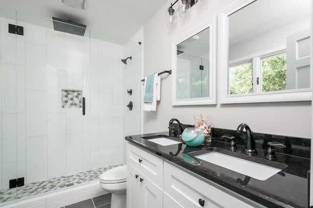 bathroom with a stall shower, a sink, and toilet