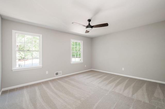 empty room featuring a ceiling fan, baseboards, visible vents, and carpet flooring