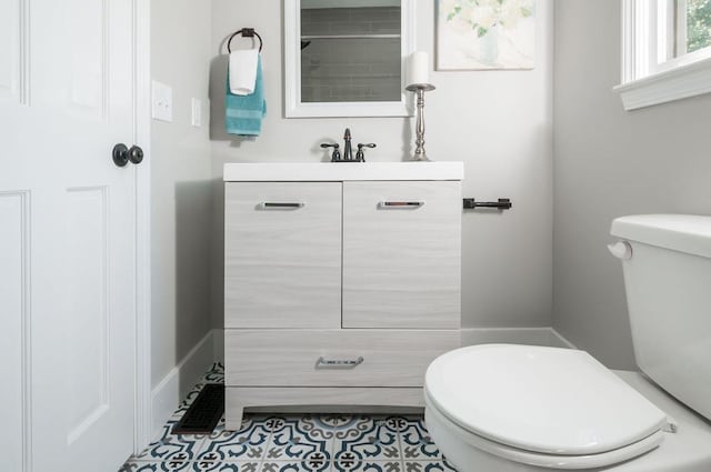 bathroom with toilet, tile patterned floors, and vanity