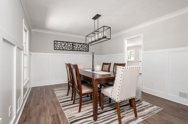 dining room with wainscoting, dark wood finished floors, visible vents, and crown molding