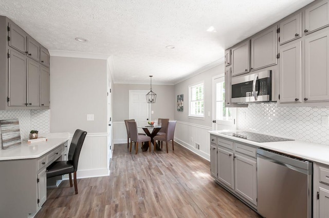 kitchen with appliances with stainless steel finishes, gray cabinets, and light countertops