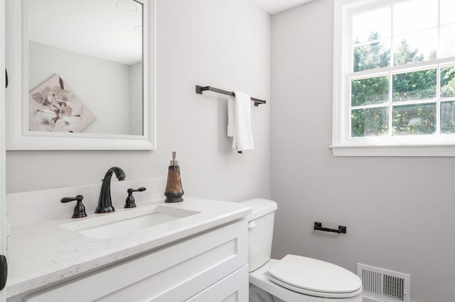 bathroom with visible vents, vanity, and toilet