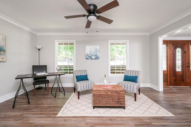 sitting room with ornamental molding, a wealth of natural light, baseboards, and wood finished floors