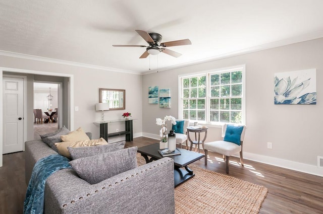 living area featuring a ceiling fan, crown molding, baseboards, and wood finished floors