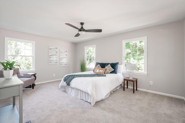 bedroom with multiple windows, baseboards, and light colored carpet