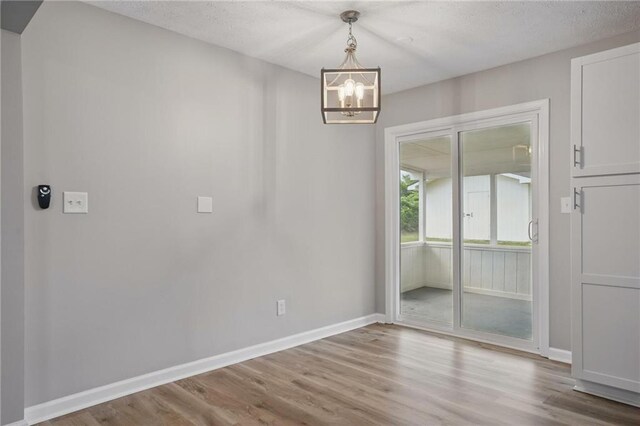 46 Forkwood Cir, Hiram, GA 30141 - unfurnished dining area with a textured ceiling, a notable chandelier, wood finished floors, and baseboards